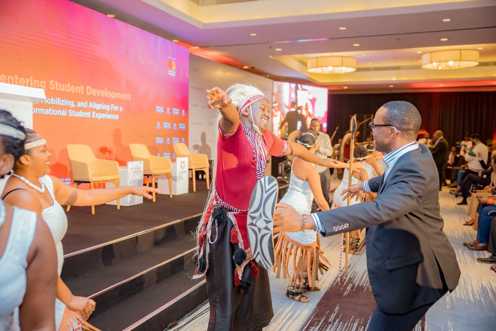 African performers engaging with an attendee at a professional event